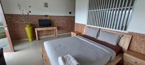 a bedroom with a large bed and a television at The Kayuan in Kintamani