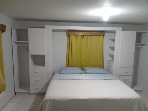 a bedroom with a bed with a yellow curtain at JeZAmi Hideaway in Nuku‘alofa