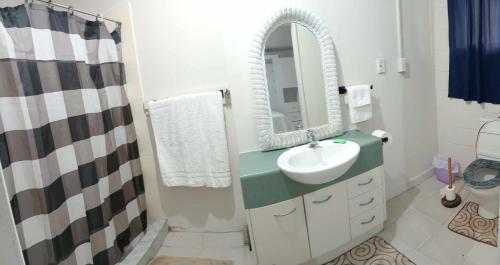 a white bathroom with a sink and a mirror at JeZAmi Hideaway in Nuku‘alofa