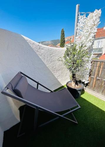 une chaise violette posée au sommet d'une cour dans l'établissement Appartement à 300m de la plage, à Toulon