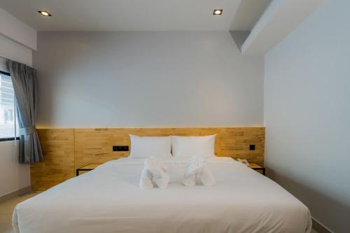 a bedroom with a large white bed with white pillows at Lek Lek Samui Room X Coffee Bar in Chaweng