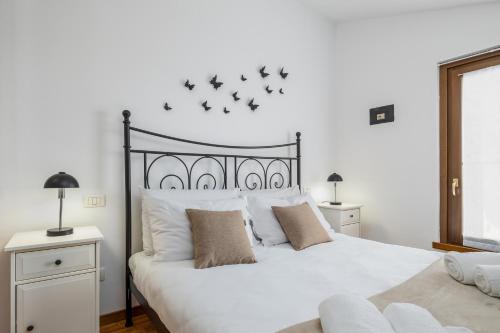 ein Schlafzimmer mit einem großen weißen Bett mit Vögeln an der Wand in der Unterkunft Lago di Garda VC, dimora Charme of Butterfly in Cavaion Veronese