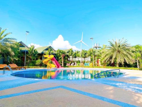 a swimming pool with a slide in a resort at Huan Soontaree in Ban Phe