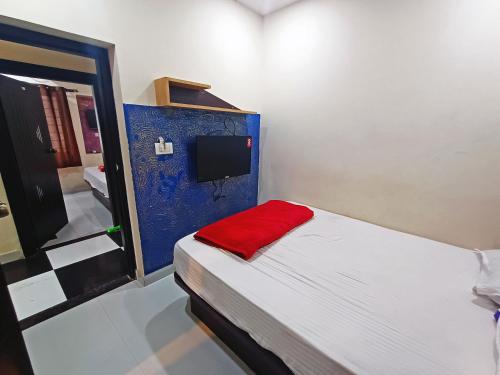 a small bedroom with a bed with a red blanket at MG Residency in Chikmagalūr