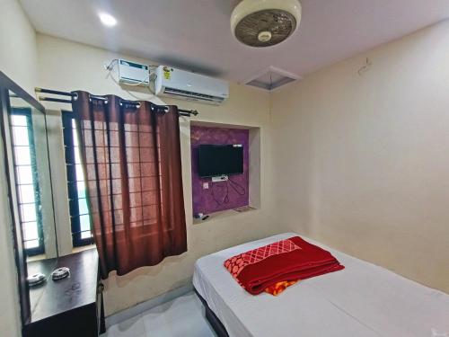 a room with a bed and a window with a red towel at MG Residency in Chikmagalūr