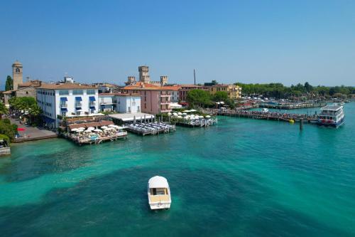 a small boat in the water near a harbor at Hotel Flaminia in Sirmione