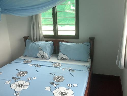 Un pat sau paturi într-o cameră la Ndovu Cottage - Nyali