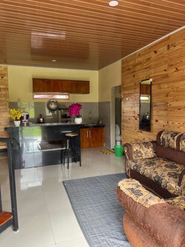 a living room with a couch and a kitchen at Ulina Villa Segitiga Berastagi in Berastagi