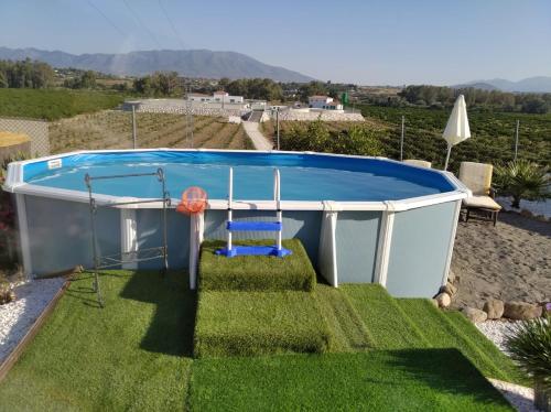 ein kleiner Pool in einem Hof mit einem Stuhl und einer Schaukel in der Unterkunft Home Benitez Pizarra in Pizarra