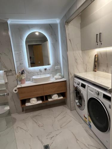 a bathroom with a sink and a washing machine at ADELAIDE CBD APARTMENT - 3BR, 2BATH & CARPARK in Adelaide