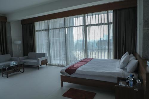 um quarto com uma cama e uma grande janela em JAKAS Resource Center em Helkunda