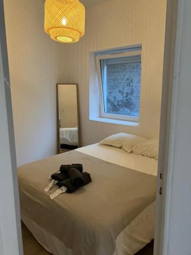 une chambre avec un lit avec un peignoir dessus dans l'établissement Leloir Appartment 2, à Tourcoing