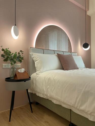 a bedroom with a white bed and a side table at 月月寓室 Luna INN 民宿 in Yilan City