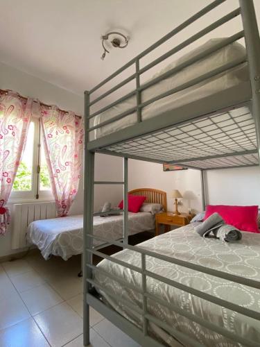 a bedroom with two bunk beds with pink curtains at Bellver 1, Ciutadella-Cala Blanca in Cala Blanca