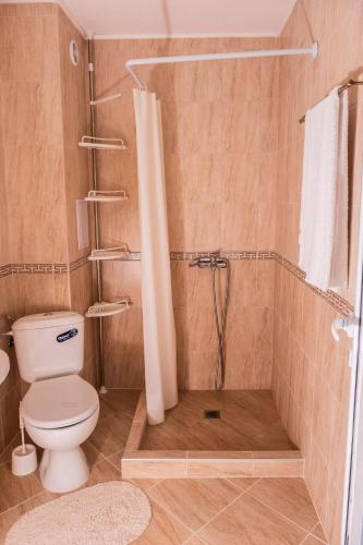 a bathroom with a shower with a toilet and a shower curtain at bellissimo студио близо до плажа in Ravda