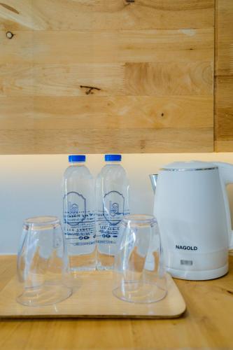 three bottles of water sitting on a counter next to a blender at Lek Lek Samui Room X Coffee Bar in Chaweng