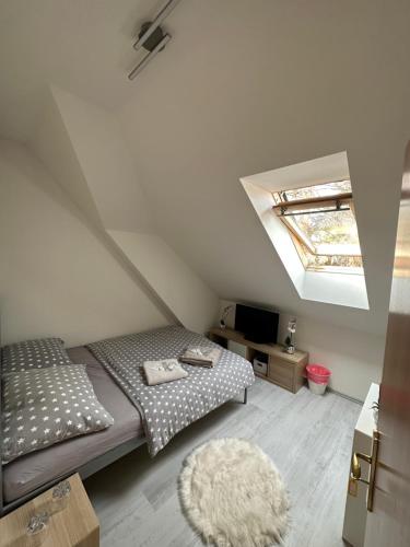 Penzion Arendel في Líšnice: غرفة نوم في العلية مع سرير ونور