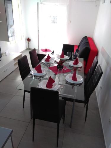 - une table à manger avec des chaises noires et des serviettes rouges dans l'établissement Apartment Mario, Novalja,fully air conditioned, à Novalja