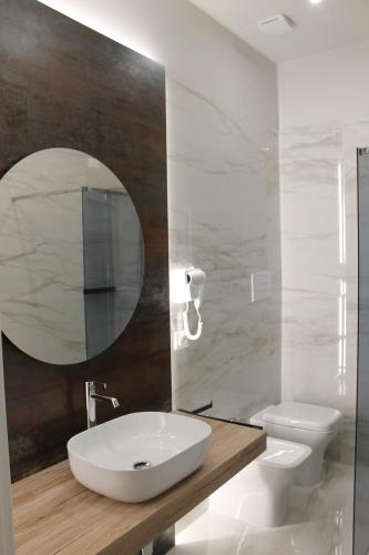 ein Badezimmer mit einem Waschbecken, einem WC und einem Spiegel in der Unterkunft B&B MariLù in Foggia