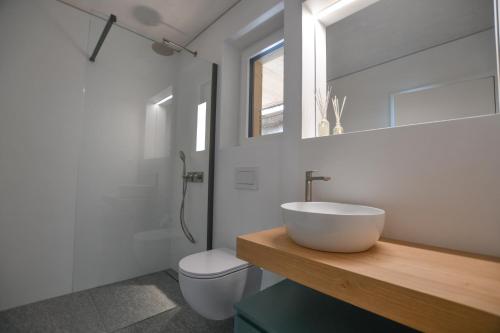 bagno con lavandino, servizi igienici e specchio di The Window a Bellinzona