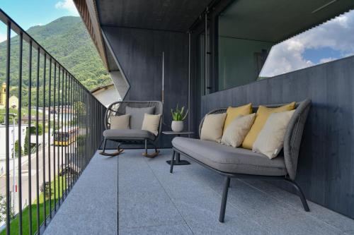a balcony with a couch and a chair at The Window in Bellinzona