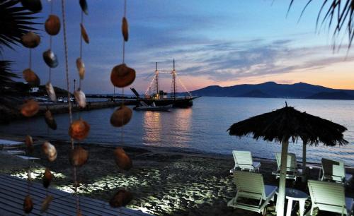 a boat in the water with chairs and an umbrella at Legato Spa Suites in Naxos Chora