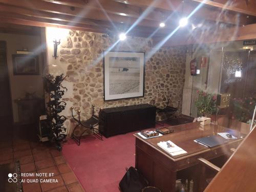an office with a desk and a stone wall at Hotel la posada de Numancia in Garray