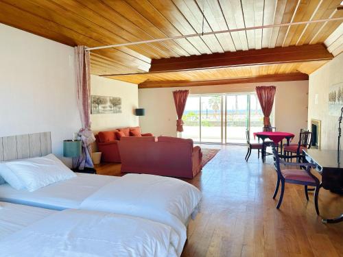 een slaapkamer met een bed, een bank en een tafel bij Yo-House in Costa da Caparica