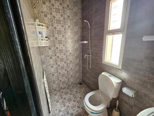 a small bathroom with a toilet and a window at Villa de Ferme Wafaa - Location de Rêve avec Piscine près de Mazagan in El Jadida