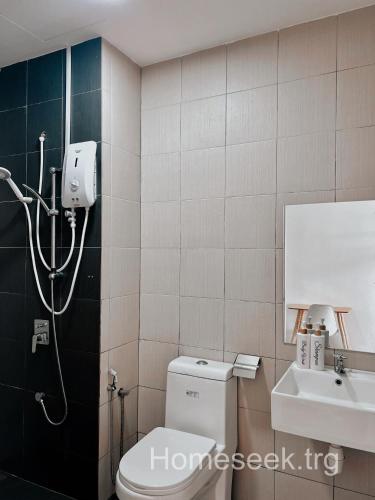 uma casa de banho com um chuveiro, um WC e um lavatório. em Homeseek, Spacious and Cozy Apartment in Kuala Terengganu em Kuala Terengganu