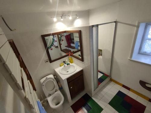 ein Badezimmer mit einem WC, einem Waschbecken und einem Spiegel in der Unterkunft Chez J-J et Pat 