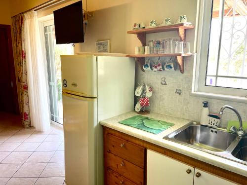 uma cozinha com um frigorífico branco e um lavatório em my Green Villa em Zakharo