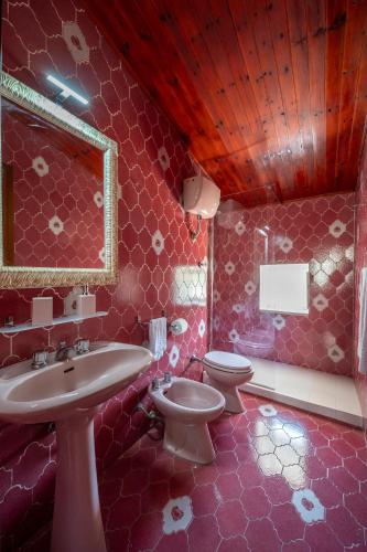 a pink bathroom with a sink and a toilet at La torretta sul cortile in Monteroduni
