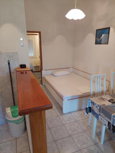a small room with a bed and a table at Apartments Delfin in Posedarje