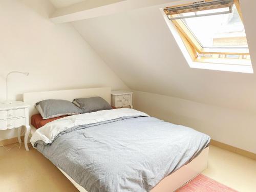 a white bedroom with a bed and a window at Sweet home in Brussels