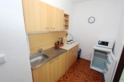 a small kitchen with a sink and a microwave at Penzion Mauritz in Nová Pec