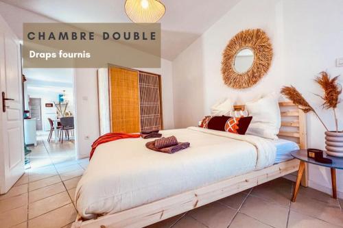 une chambre avec un grand lit et un miroir dans l'établissement Le Gite 1 - Appartement T2 de 53m2, idéal pro ou couples, coeur de ville et proche GOLFECH, à Malause