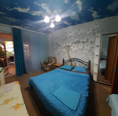 a bedroom with a blue bed with a blue ceiling at Гостевой дом ЛОНТАНА in Gagra