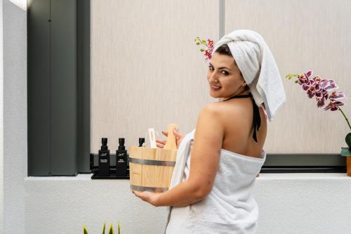 a woman with a towel on her head holding a basket of wine at Legato Spa Suites in Naxos Chora