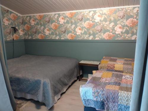 Muuruvesi的住宿－SkillHill，一间卧室设有两张床和花卉壁纸