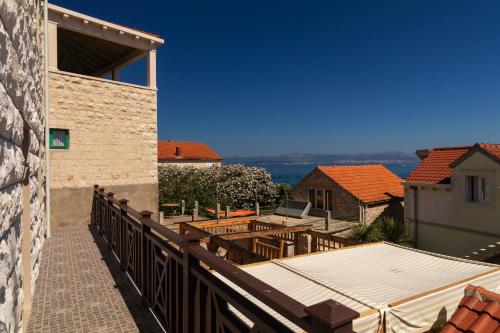 einen Balkon eines Hauses mit einem Tisch und Stühlen in der Unterkunft Taverna & Rooms in Sutivan