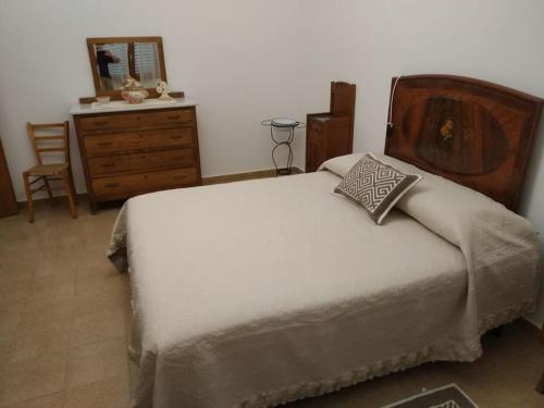 a bedroom with a bed with a dresser and a mirror at CasaFigus La Terrazza NARBOLIA in Narbolia
