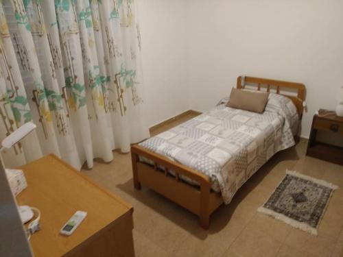 a small bedroom with a bed and a table at CasaFigus La Terrazza NARBOLIA in Narbolia
