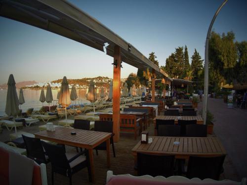 a restaurant with tables and umbrellas on a beach at Manuela Boutique Hotel Bitez in Bitez