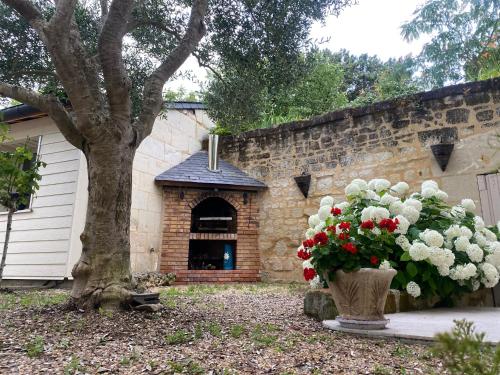 a vase filled with flowers sitting next to a building at Logis huit clos calme et romantique proche Saumur in Le Coudray-Macouard