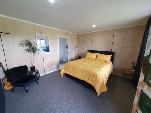 a bedroom with a bed and a chair in it at Hunts Farm - Te Kūiti in Te Kuiti