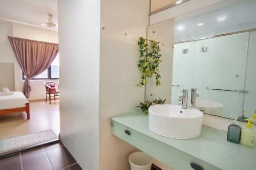 ein weißes Badezimmer mit einem Waschbecken und einem Spiegel in der Unterkunft Cozyhome Encorp Strand Alpha IVF 4px in Petaling Jaya