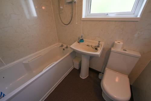 a bathroom with a sink and a toilet and a bath tub at Ash, Birch and Rowan Cabins in Onich