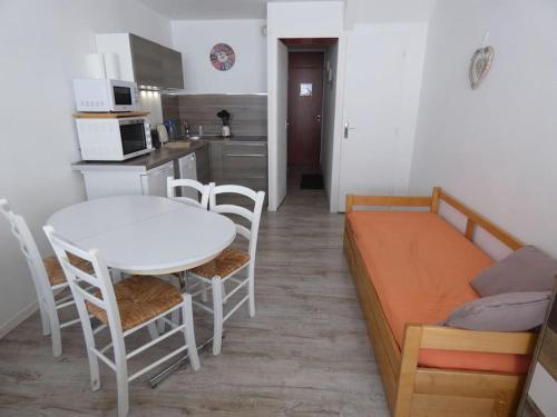 une chambre avec un lit, une table et des chaises dans l'établissement Studio 4 pers pied des pistes, à Bagnères-de-Bigorre