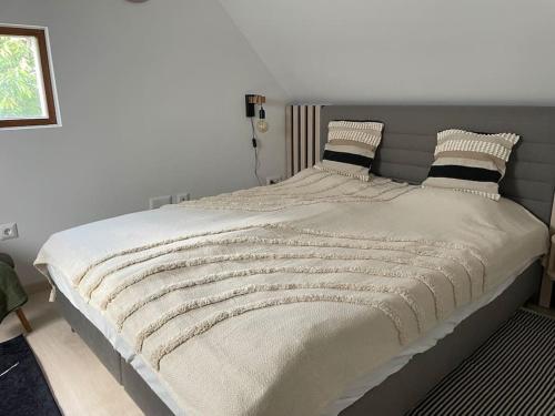 sypialnia z dużym łóżkiem z szarym zagłówkiem w obiekcie Morris Vacka w mieście Veszprém